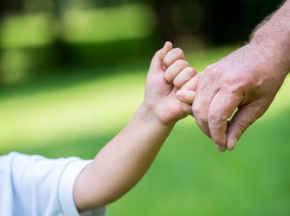 photo of a child holding an adult's hand
